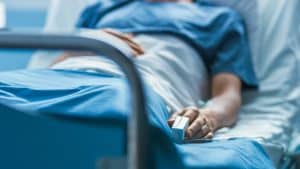 A patient sits alone in a hospital bed without proper care in Charleston, West Virginia.