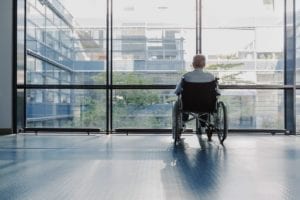 Senior Man in Wheelchair Looking Out Window