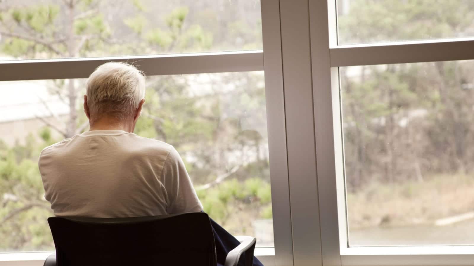 Senior Man Staring Out The Window Stock Photo