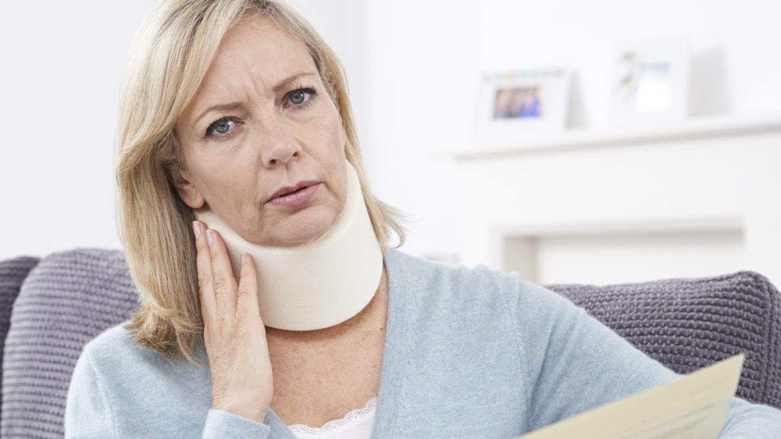 Mature Woman Reading Letter After Receiving Neck Injury