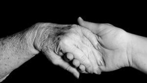 Young Woman Holding Hands With An Elderly Woman