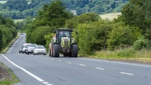 Tractor Driving On A Rural Road Stock Photo