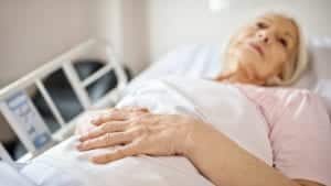 Elder Woman In Hospital Bed Stock Photo