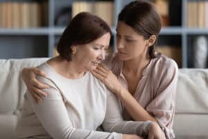 a daughter comforting her mother after learning of nursing home abuse