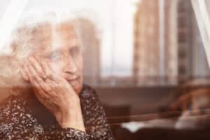 A Charleston, WV, nursing home resident looking out the window of her room