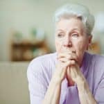 An older woman looking depressed after suffering elder abuse.