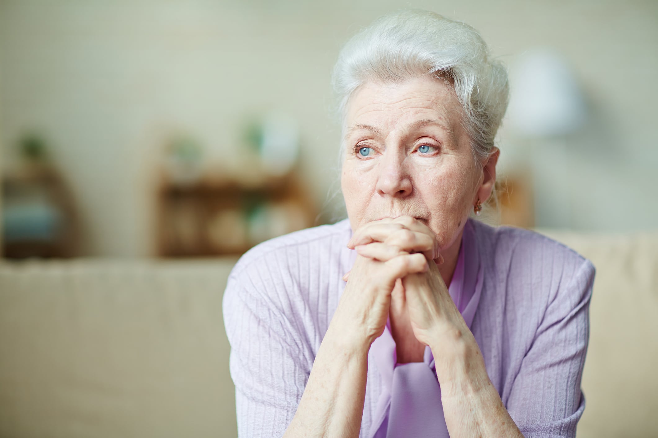 An older woman looking depressed after suffering elder abuse.