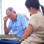 A woman comforting her dad after he suffered elder neglect.