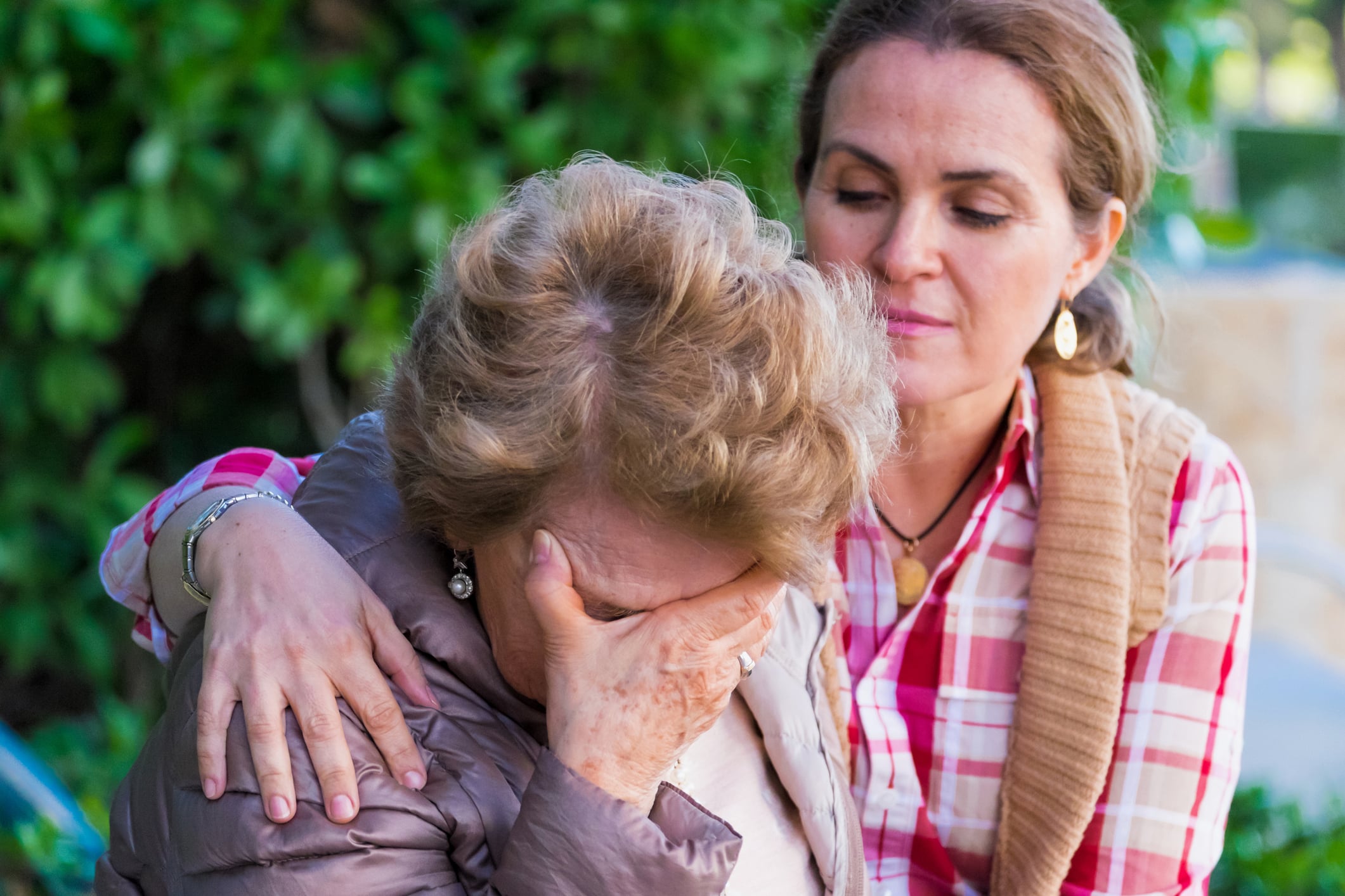 A woman consoling her elderly mother.