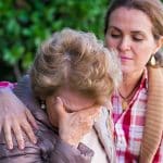 A woman consoling her elderly mother after experiencing nursing home abuse